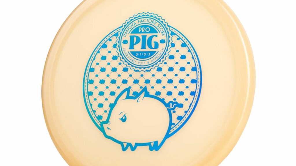 A cream colored Innova Pro Pig Stiff Putter Disc with Blue gradient stamp.

The text on the image says Innova Factory Store Pro Pig with flight number 3, 1, 0, 3, Overstable Put & Approach

The image on the disc presents an adorable pig with a frown, adorned with intricate patterns and enclosed within a circular frame.