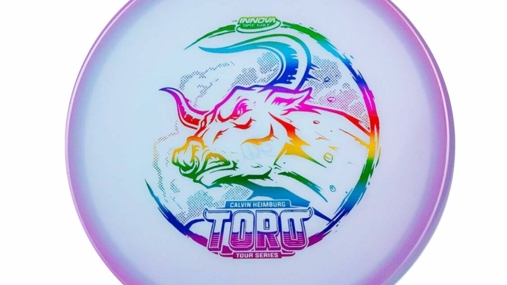An Innova Toro (Calvin Heimburg Color Glow) Purple Disc w/Rainbow Stamp. On the disc, there is an image of a fighting bull positioned towards the left.